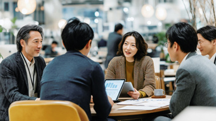 Group of people sitting at a table and discussing statistics and research
