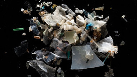Plastic debris of varying sizes on a black background