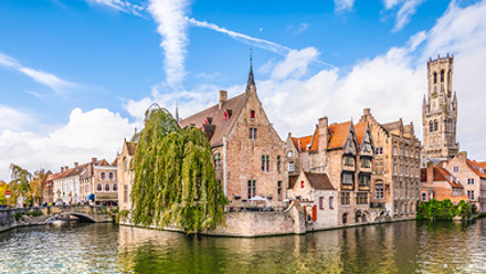 Panoramic city view with historical houses, church, Belfry tower and famous canal in Bruges, Belgium