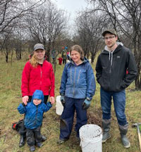 LSETAC members and their family in a stand of trees with tree-planting equipment